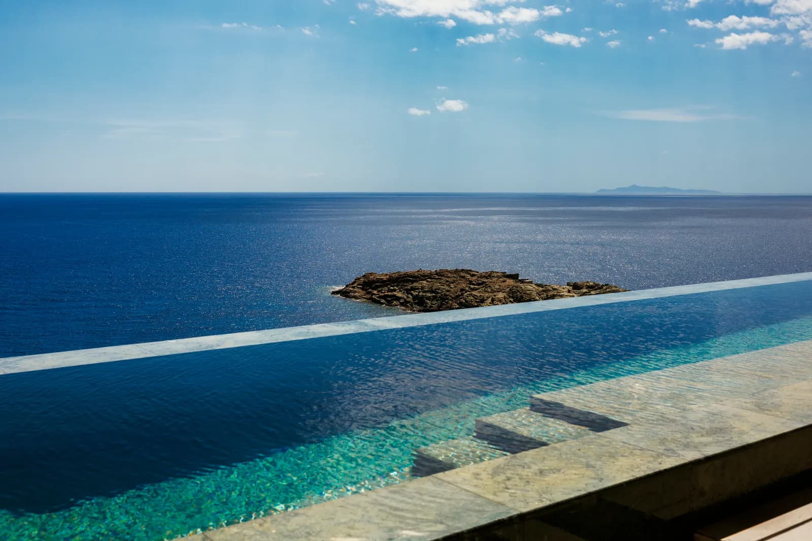 Pool des Bond Beach Club in der Bucht von Vroskopos
