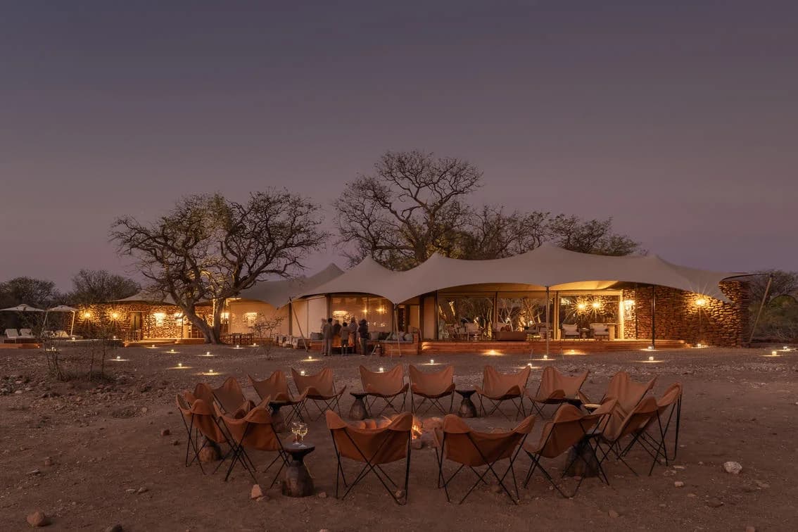 Desert Rhino Camp mit gedeckten Tischen in der Abenddämmerung