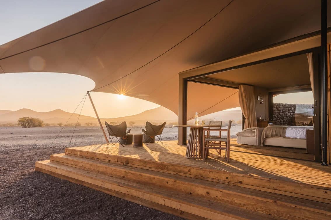 Desert Rhino Camp – Bett und Deck am Morgen