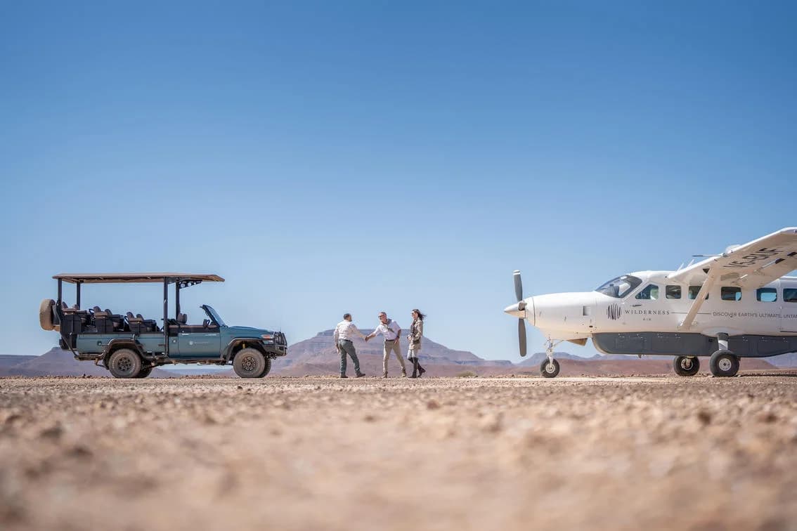 Desert Rhino Camp – Safarifahrzeug und Cessna 208 am Airstrip